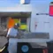 A person wearing a helmet stands next to a colorful food truck with a service window open.